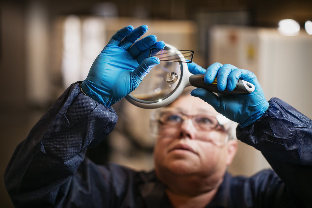 Scientist looking at sequencing flow cell